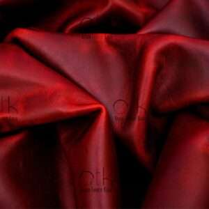 Vibrant maroon pull-up leather, ready for crafting high-quality leather products.